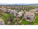 An aerial view shows a neighborhood nestled in green landscape with mountain views in the distance at 10632 Star Thistle Ct, Highlands Ranch, CO 80126