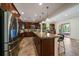 Large kitchen with stainless appliances, dark wood cabinets, a central island, and access to the backyard at 10632 Star Thistle Ct, Highlands Ranch, CO 80126