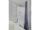 Well-lit bathroom featuring a shower with gray curtain and a convenient toilet nearby at 690 W Jamison Cir, Littleton, CO 80120
