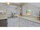 Well-appointed kitchen featuring white cabinetry, stainless steel appliances and an open view to the dining area at 690 W Jamison Cir, Littleton, CO 80120