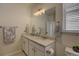 Bright bathroom featuring double sinks with granite counters and a large mirror at 7470 Blue Water Ln, Castle Rock, CO 80108