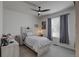 A bedroom with a ceiling fan, a light color palette, a comfortable bed, and large windows at 7470 Blue Water Ln, Castle Rock, CO 80108