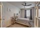 A bedroom with a ceiling fan, a light color palette, a comfortable bed, and large windows at 7470 Blue Water Ln, Castle Rock, CO 80108