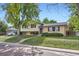 Street view of two-story home with brick facade, tidy landscaping, and sidewalk at 11797 Keough Dr, Northglenn, CO 80233