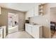 Neutral kitchen featuring tile floors, classic white cabinets, and a view into an adjacent dining area at 11797 Keough Dr, Northglenn, CO 80233