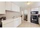 Functional kitchen featuring white cabinets, black appliances, and linoleum flooring at 11797 Keough Dr, Northglenn, CO 80233