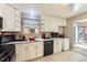 Well-lit kitchen with linoleum floors, black appliances, and window for natural light at 11797 Keough Dr, Northglenn, CO 80233