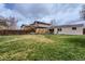Large backyard with a wood fence, small garden, covered patio, and an upper and lower level home at 2965 S Birch St, Denver, CO 80222