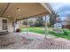 Covered brick patio leads to a large backyard with a small storage shed and a wood fence at 2965 S Birch St, Denver, CO 80222