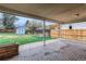 A covered brick patio overlooks a spacious, fenced backyard with a small storage shed and mature trees at 2965 S Birch St, Denver, CO 80222
