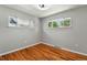 This bedroom features hardwood floors, light gray walls, and two large windows with natural light at 380 S Jersey St, Denver, CO 80224