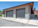 Modern two-car garage featuring stone accents, concrete driveway, with staircase access to additional space above at 380 S Jersey St, Denver, CO 80224