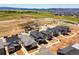 New homes in a residential community nestled near green hills and mountains, showcasing neighborhood layout at 7291 Prairie Sage Pl, Littleton, CO 80125