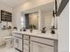 Bright bathroom featuring double vanity, large mirror and stylish fixtures at 7291 Prairie Sage Pl, Littleton, CO 80125