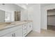 Modern bathroom featuring double sinks, a large mirror, and a glass-enclosed shower at 7291 Prairie Sage Pl, Littleton, CO 80125