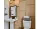 Charming powder room with pedestal sink, decorative mirror, and wainscoting detail at 7291 Prairie Sage Pl, Littleton, CO 80125