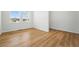 Bright, minimalist bedroom with hardwood floors and large windows providing natural light and a serene view at 7291 Prairie Sage Pl, Littleton, CO 80125