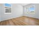 Bright, minimalist bedroom with hardwood floors and large windows providing natural light and a serene view at 7291 Prairie Sage Pl, Littleton, CO 80125