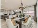 Open dining area with modern lighting, stylish chairs, and stainless steel appliances in the kitchen at 7291 Prairie Sage Pl, Littleton, CO 80125