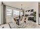 Elegant dining room with modern furniture, large windows, and decorative accents at 7291 Prairie Sage Pl, Littleton, CO 80125