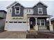 Charming two-story home featuring stone accents, attached two-car garage, and covered front porch at 7291 Prairie Sage Pl, Littleton, CO 80125