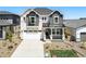Beautiful two-story home with stone accents, a two-car garage, a covered porch, and well-maintained landscaping at 7291 Prairie Sage Pl, Littleton, CO 80125
