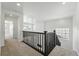 Upstairs hallway featuring wood railing and carpeted floors at 7291 Prairie Sage Pl, Littleton, CO 80125