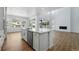 Modern kitchen with stainless steel appliances, island, and open concept to living area at 7291 Prairie Sage Pl, Littleton, CO 80125