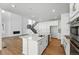 Open-concept kitchen with white cabinets, island, stainless appliances, and view of the living room at 7291 Prairie Sage Pl, Littleton, CO 80125