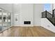 Bright living room featuring wood floors, fireplace, and staircase with black railings at 7291 Prairie Sage Pl, Littleton, CO 80125