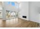 Living room with a modern fireplace, tall ceilings, hardwood floors, and sliding glass doors to an outdoor patio at 7291 Prairie Sage Pl, Littleton, CO 80125