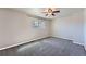Bright bedroom featuring a modern ceiling fan, large window, and neutral carpeting at 15139 E Wesley Ave, Aurora, CO 80014