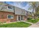 View of a brick townhome row with green lawns and mature trees showcasing the community's curb appeal at 15139 E Wesley Ave, Aurora, CO 80014