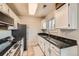 Efficient kitchen featuring white cabinets, granite countertops and modern appliances for easy meal prep at 15139 E Wesley Ave, Aurora, CO 80014