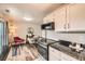 Open kitchen space next to a dining area with modern appliances, white cabinets and hardwood style floors at 15139 E Wesley Ave, Aurora, CO 80014