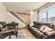 Cozy living room featuring a leather sofa, adjacent to a staircase, with a neutral color palette at 15139 E Wesley Ave, Aurora, CO 80014