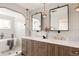 Elegant bathroom with dual vanity, stylish mirrors and lighting, glass enclosed shower, and a soaking tub at 3932 Kalamath St, Denver, CO 80211