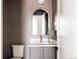 Bathroom featuring gray cabinets, a marble sink, a round framed mirror, and modern lighting at 3932 Kalamath St, Denver, CO 80211