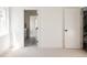 Bright bedroom with plush carpet, white walls, open doorway with view of cabinets, and black door fixtures at 3932 Kalamath St, Denver, CO 80211