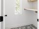 Bright laundry room with floating wood shelves, window, and gray-tiled floors at 3932 Kalamath St, Denver, CO 80211