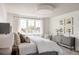 Bright main bedroom with white walls, wood-planked ceiling, a large window, and stylish furnishings at 3932 Kalamath St, Denver, CO 80211