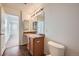 Simple bathroom featuring tile floors, a brown vanity, and a large mirror over the sink at 15786 Randolph Pl, Denver, CO 80239