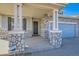 Inviting covered front porch with stone pillars, leading to the home's entrance and garage at 15786 Randolph Pl, Denver, CO 80239