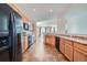 Open kitchen layout showcases wood cabinets, black appliances, and easy flow to the adjacent living areas at 15786 Randolph Pl, Denver, CO 80239