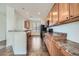 Efficient kitchen featuring wood cabinets, black appliances, and a breakfast bar at 15786 Randolph Pl, Denver, CO 80239