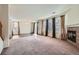 Bright living area featuring neutral carpet, a fireplace, and sliding glass doors to the backyard at 15786 Randolph Pl, Denver, CO 80239