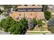 An aerial view showcases townhomes with skylights, surrounded by mature trees and a wooden fence at 2092 S Helena St # C, Aurora, CO 80013