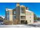 Two-story building exterior, stone accents, and snowy landscape at 4896 S Dudley St # 7-7, Littleton, CO 80123