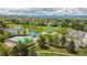 Expansive aerial view showcasing the community pool, tennis courts, playground, and surrounding residential area with mountain views at 1462 Raindrop Way, Castle Rock, CO 80109