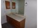 Bathroom vanity featuring a white countertop with a sink below a mirror and wooden cabinetry at 453 S Kittredge St # D, Aurora, CO 80017
